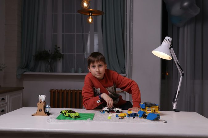 un jeune garçon jouant avec un ensemble de Lego sur une table