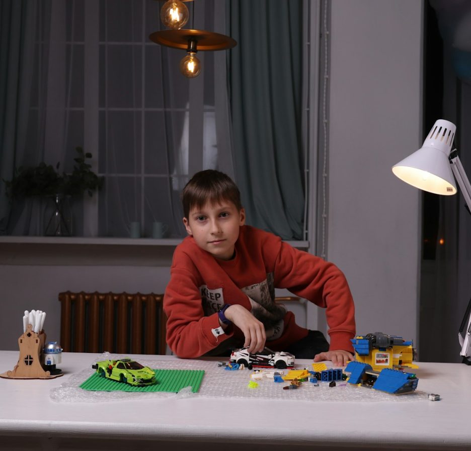 un jeune garçon jouant avec un ensemble de Lego sur une table