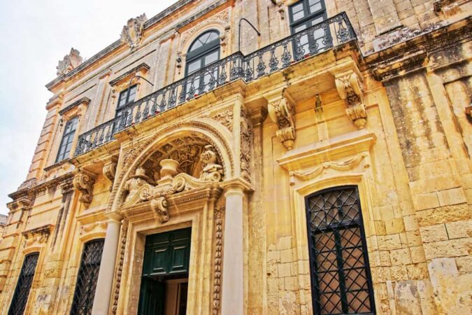 Détails sculptés de la façade d'un hôtel particulier typique du centre historique de Montpellier avec ses balcons en fer forgé.