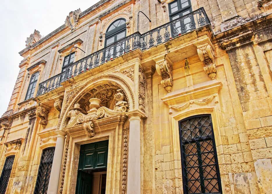 Détails sculptés de la façade d'un hôtel particulier typique du centre historique de Montpellier avec ses balcons en fer forgé.