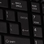 Clavier d'ordinateur noir avec touches "Backspace", "Enter", "Shift", et chiffres