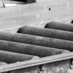 Rouleaux métalliques alignés dans une cadre métallique, fonction transport