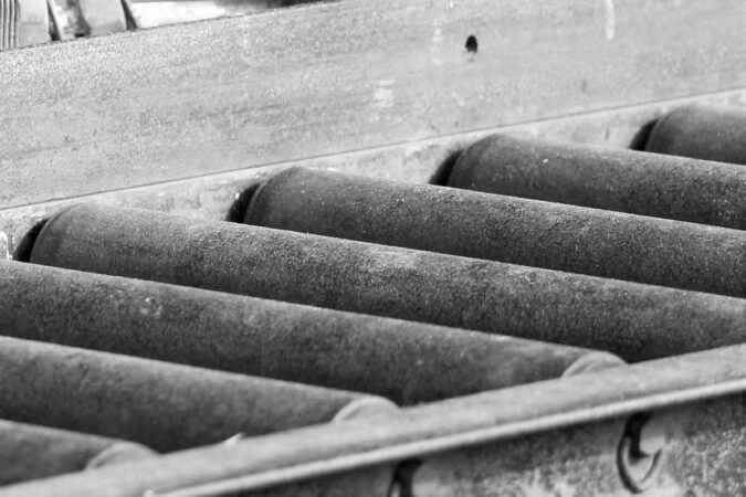 Rouleaux métalliques alignés dans une cadre métallique, fonction transport