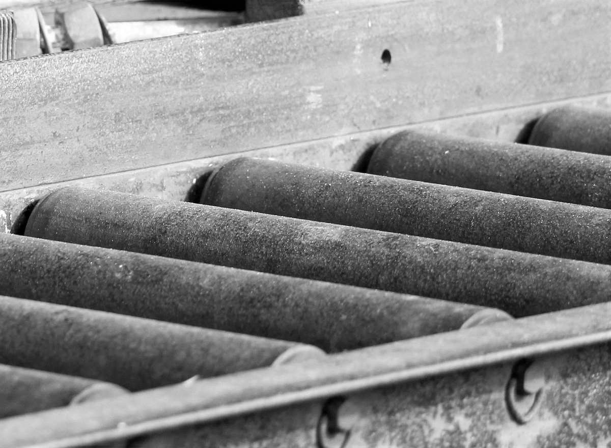 Rouleaux métalliques alignés dans une cadre métallique, fonction transport