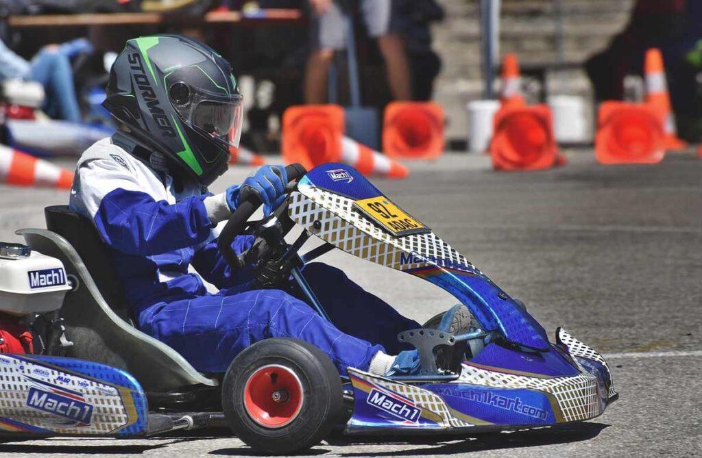 Un conducteur en combinaison bleue pilote un kart de course