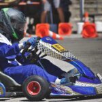 Un conducteur en combinaison bleue pilote un kart de course