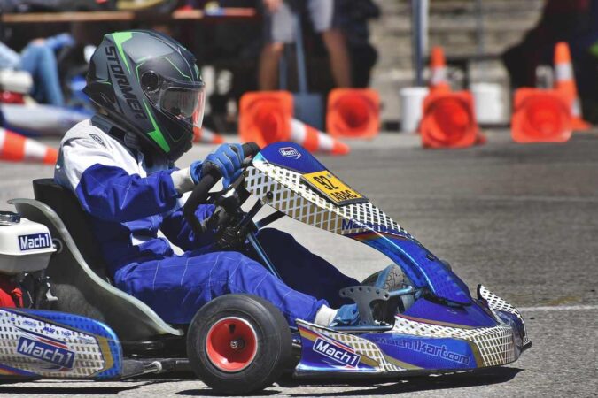 Un conducteur en combinaison bleue pilote un kart de course
