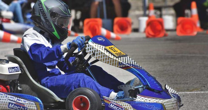 Un conducteur en combinaison bleue pilote un kart de course