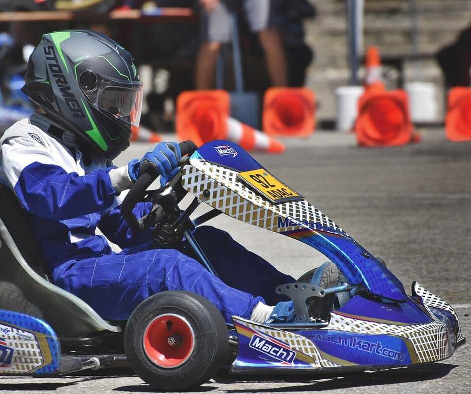 Un conducteur en combinaison bleue pilote un kart de course