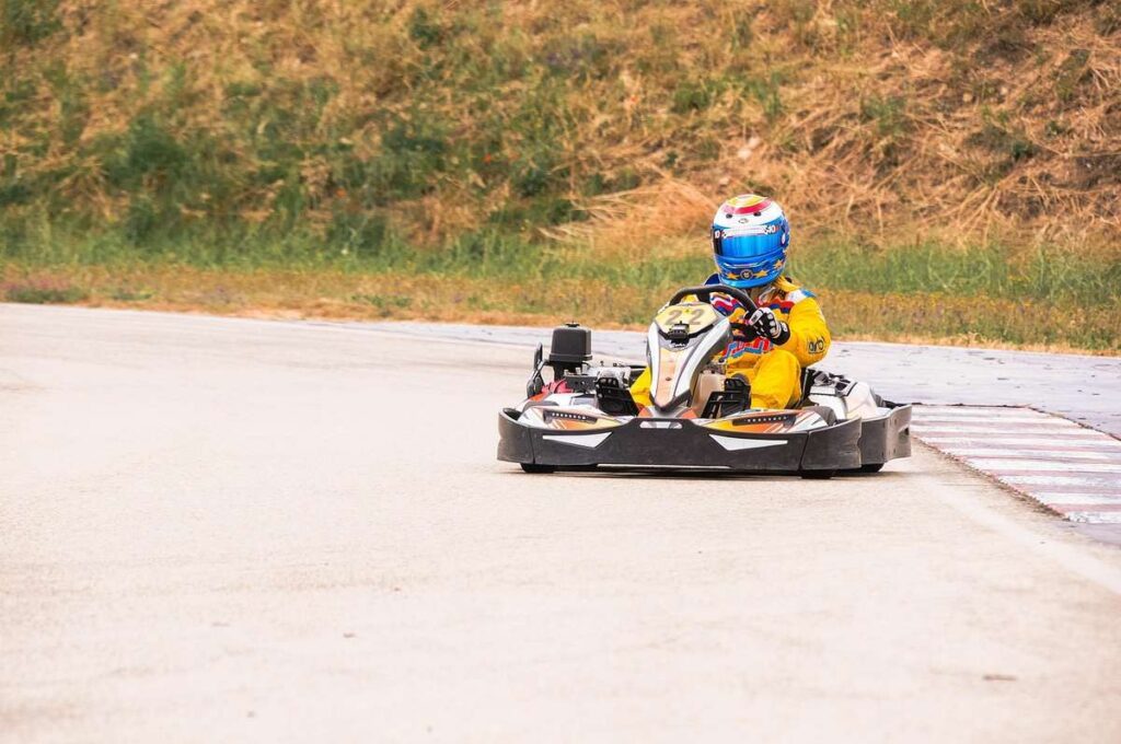 Kart sur piste avec conducteur en combinaison jaune
