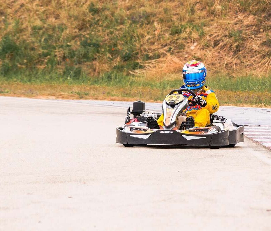Kart sur piste avec conducteur en combinaison jaune