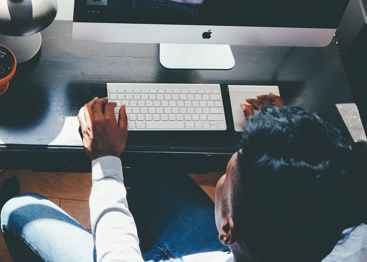 Un individu utilise un ordinateur de bureau avec clavier et souris Un individu utilise un ordinateur de bureau avec clavier et souris